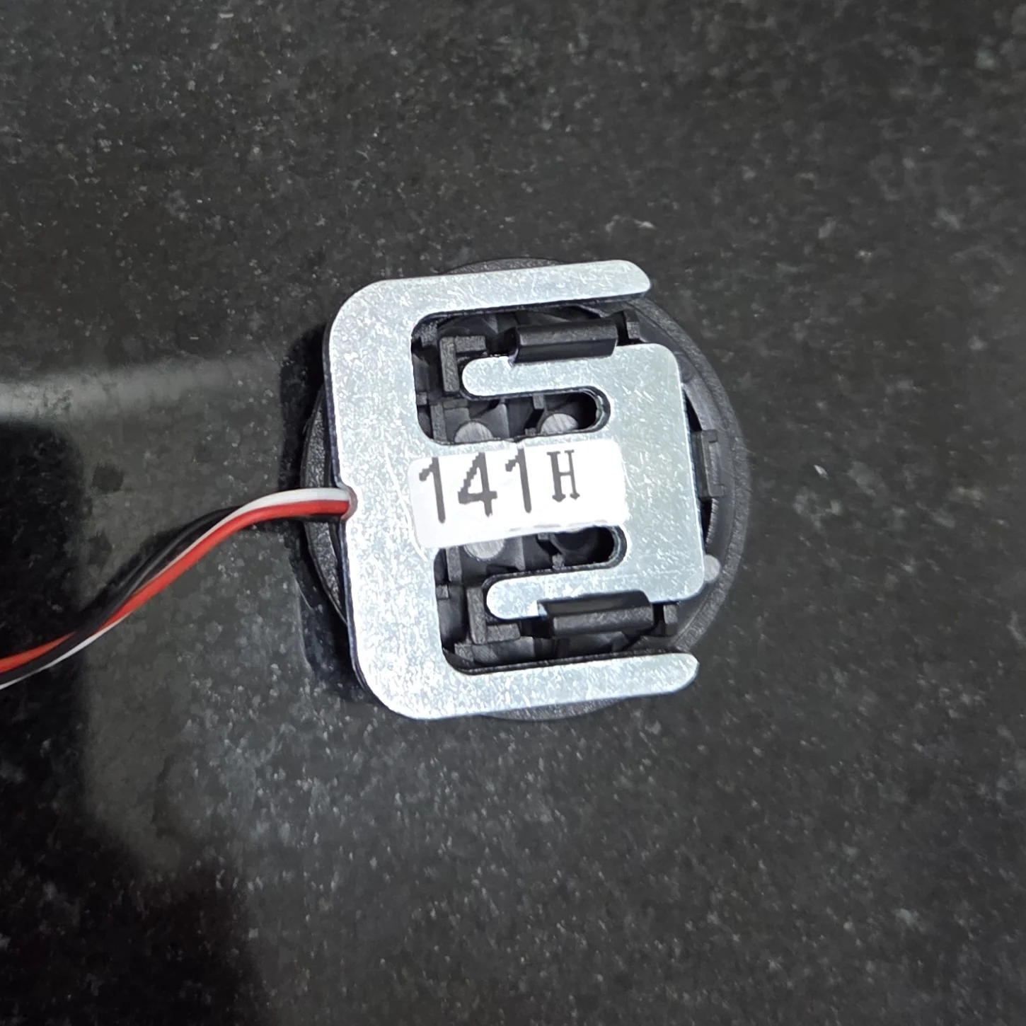 Metal force sensor removed from a household scale, with three wires visible